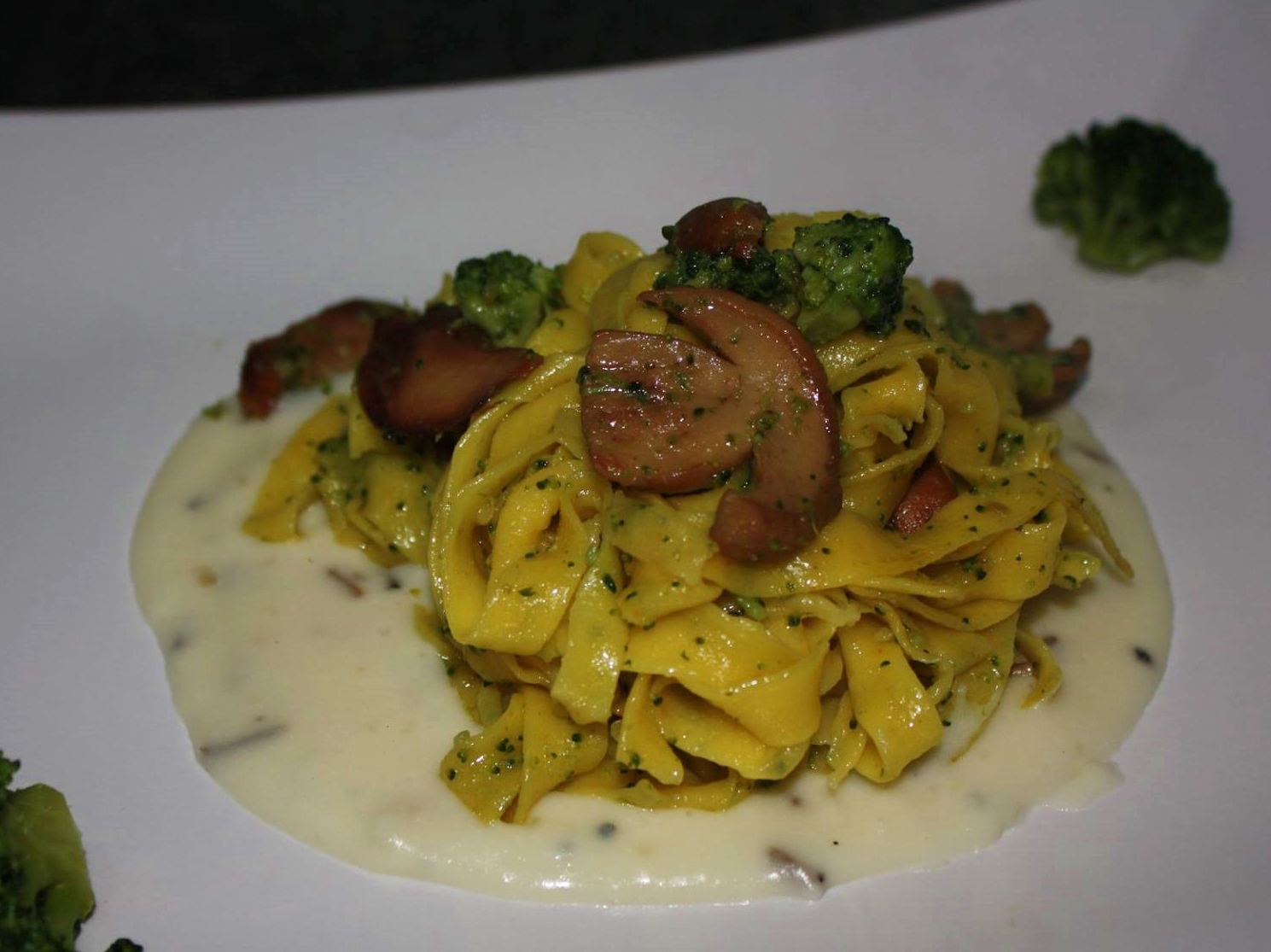 Fettuccine colorate allo zafferano con broccoli e porcini su fonduta di formaggio al tartufo